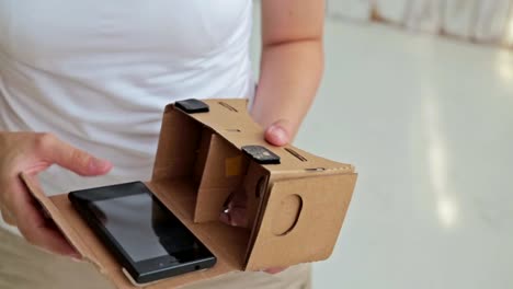 Young-curly-woman-using-Virtual-Reality-Glasses.-Google-cardboard