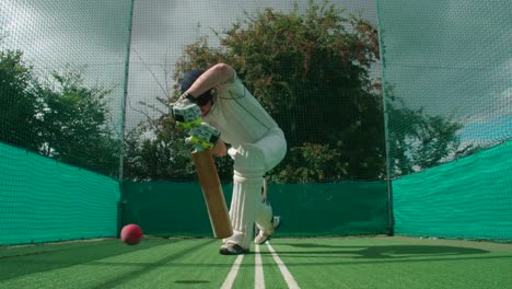 Un-jugador-haciendo-práctica-red-pega-a-la-pelota-de-cricket.