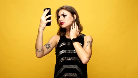 Upset-lady-with-halloween-make-up-using-smartphone-and-displeased-about-her-look-isolated-over-yellow