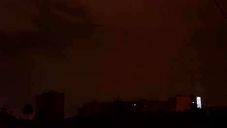 Blick-aus-dem-Fenster-in-den-stürmischen-Himmel.-Nacht-im-Freien,-außerhalb-des-Fensters-gekleidet-mit-Regen-und-Donner-blitzte.-aus-dem-Fenster-hohen-Häusern-FullHD-gesehen