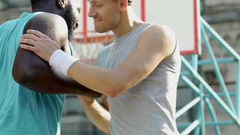 Two-friends-greeting-each-other-making-cool-handshake-before-basketball-game