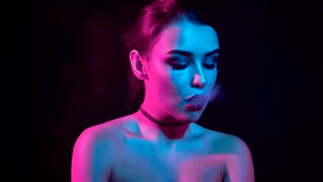 Gorgeous-brunette-woman-smoking-electronic-cigarette-in-neon-color-light