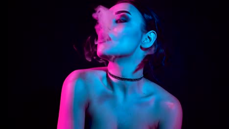 Gorgeous-brunette-woman-smoking-electronic-cigarette-in-neon-color-light