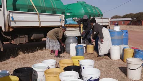 Los-africanos-recolectando-agua-en-recipientes-de-una-cisterna-de-agua-debido-a-la-sequía-en-África-del-sur