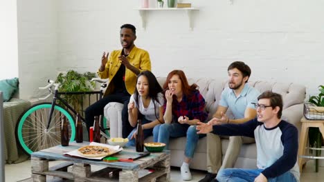 Slow-motion-of-Young-friends-watching-football-game-on-TV-together-at-home-and-disappointed-about-their-favourite-team-losing-match