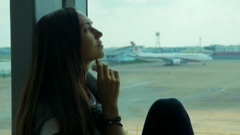 Young-sad-woman-is-crying-at-airport-with-airplane-on-the-background