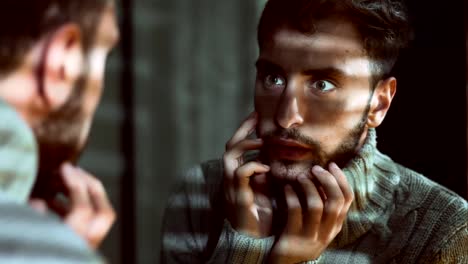 Sad-depressed-Young-Man-looking-in-the-The-Mirror-inn-the-dark