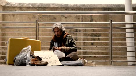 The-homeless-are-scraping-fungus-from-the-bread-while-waiting-for-donations-from-person-walking-on-the-sidewalk.