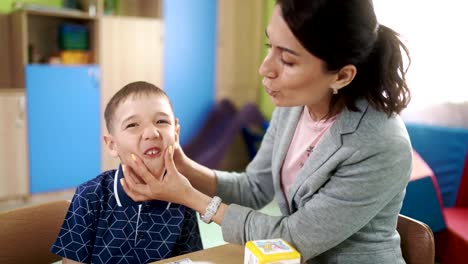 El-terapeuta-del-habla-de-una-mujer-y-un-niño-durante-una-lección-a-la-correcta-articulación