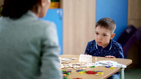 The-cute-boy-is-doing-the-breathing-exercise-at-speech-therapy-session