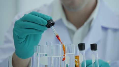 Close-up-of-a-scientist-with-a-pipette-analyzes-a-colored-liquid-to-extract-the-DNA-and-molecules-in-the-test-tubes