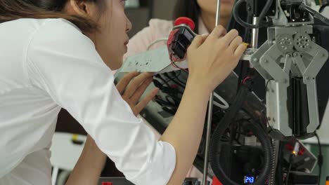 Team-of-robotics-engineer-works-with-robot,-assembling-and-testing-robotics-responses-with-laptop-Computer-in-workshop.-People-with-technology-or-innovation-concept.