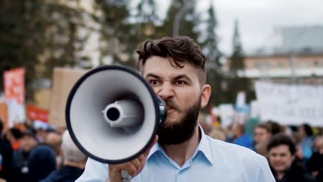 Young-adult-man-shouts-in-megaphone.-He-screams-violently-and-angry-slow-motion.