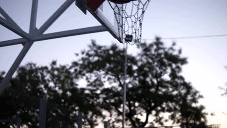 Basketball-female-player-playing-a-game-of-one-on-one.-The-player-with-the-ball-runnung-and-maling-a-hoop.-Outdoors