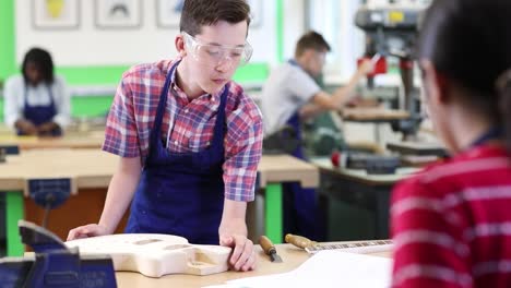 Männlich-High-School-Student-Gebäude-Gitarre-In-Holzarbeiten-Lektion