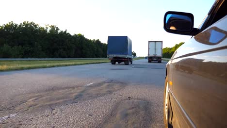 Schwarzes-Auto-fahren-auf-der-Straße-in-die-Landschaft.-Schöne-Landschaft-spiegelt-sich-auf-die-Auto-Tür.-Verkehr-in-ländlichen-Gebieten.-Sicht-Slow-motion