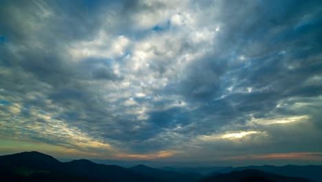 The-beautiful-cloud-stream-with-a-sunset-above-mountains.-time-lapse