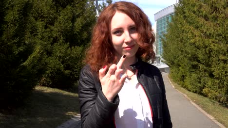 Outdoor-lifestyle-close-up-of-a-white-sexy-redhead-lady-show-middle-finger