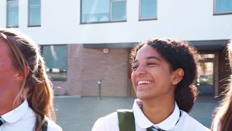 Portrait-Of-Smiling-Female-High-School-Students-Wearing-Uniform-Outside-College-Building