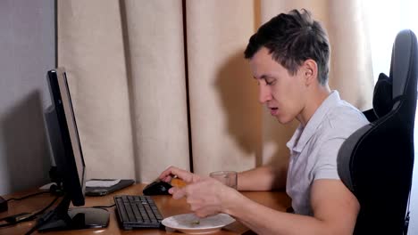 Man-at-home-eating-pizza-and-playing-on-the-computer