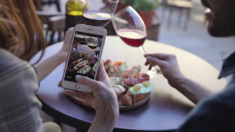 Closeup-Frau-Fotografieren-von-Essen-und-Wein-im-Restaurant.