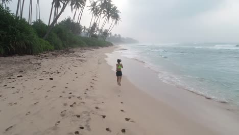 Gesunde-Lebensweise-junge-Frau-läuft-am-tropischen-Strand-bei-Sonnenaufgang-am-Morgen