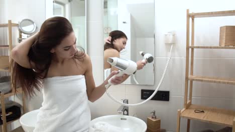 Hair-Care.-Frau-trocknen-lange-Haare-mit-Fön-im-Badezimmer