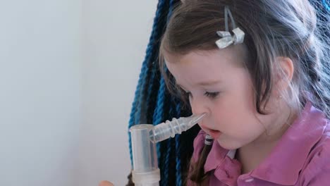 Little-cute-girl-inhaling-through-inhaler-mask-with-her-mom.-Use-nebulizer-and-inhaler-for-the-treatment.