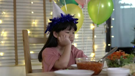 Asian-kids-girl-waiting-father-and-mother-coming-home-birthday-party-and-dinner-together.-Unhappy-family-time-at-home.-Concept-of-lonely,-disappointed-and-sad.