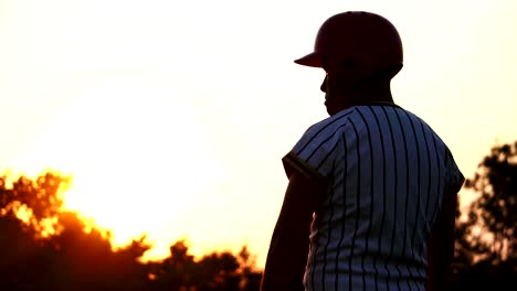 Baseball-Spieler-hält-einen-Baseball-mit-dem-Licht-des-Sonnenuntergangs