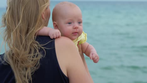 Mama-mit-Baby-Tochter-genießen-Meer-und-Brise