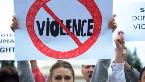 Crowd-with-posters-chanting-Stop-violence-slogans,-domestic-abuse,-human-rights