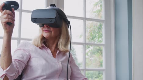 Reife-behinderte-Frau-im-Rollstuhl-zu-Hause-mit-Virtual-Reality-Headset-Gaming-Holding-Controller