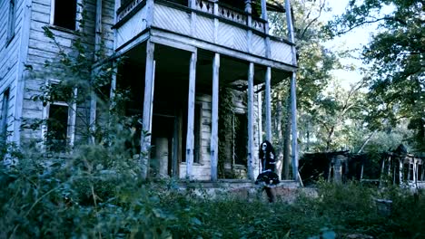 Halloween.-A-young-woman-with-make-up-of-skeleton-going-along-a-wooden-house.-4K