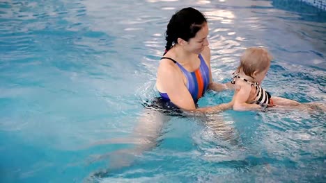 Schwimmbad.-Mama-bringt-einem-kleinen-Kind-das-Schwimmen-im-Pool-bei.