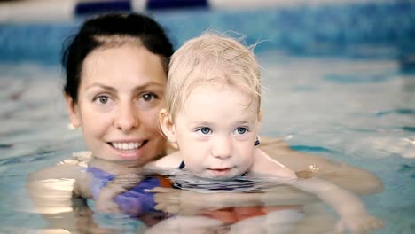 Schwimmbad.-Mama-bringt-einem-kleinen-Kind-das-Schwimmen-im-Pool-bei.