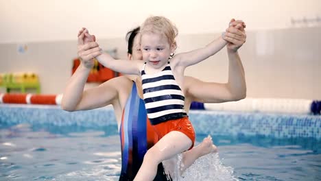 Schwimmbad.-Mama-bringt-einem-kleinen-Kind-das-Schwimmen-im-Pool-bei.