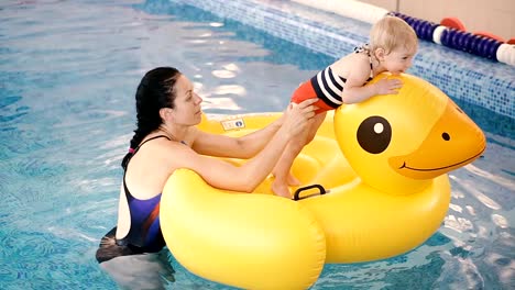 Schwimmbad.-Mama-bringt-einem-kleinen-Kind-das-Schwimmen-im-Pool-bei.