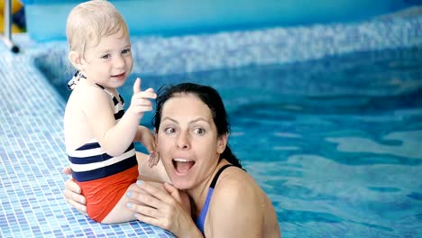 Schwimmbad.-Mama-bringt-einem-kleinen-Kind-das-Schwimmen-im-Pool-bei.