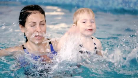 Schwimmbad.-Mama-bringt-einem-kleinen-Kind-das-Schwimmen-im-Pool-bei.