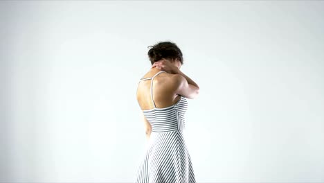 Young-female-with-neck-ache-rubbing-her-neck-against-light-background