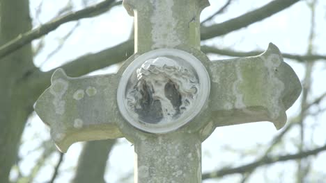 Alter-Grabstein-aus-dem-19.-Jahrhundert-an-einem-sonnigen-Frühlingstag.-Konzentrieren-Sie-sich-auf-eine-Jesus-Skulptur.-4K-in-SLOG3.-zusammenrücken.