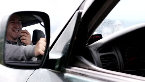 Man-holding-hand-microphon-and-talking-on-radio-in-his-car.