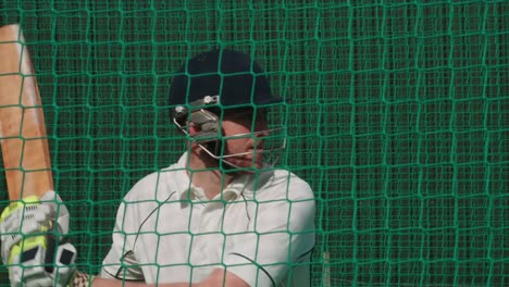 A-Cricketing-Batsman-strikes-the-cricket-ball-practising-in-the-nets.