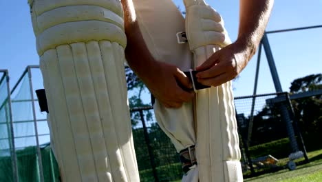 Cricketspieler-binden-seine-Watte-Pads-während-einer-Übung