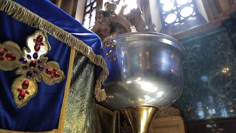 En-un-templo-religioso,-una-taza-de-metal-está-iluminado-por-un-rayo-de-sol