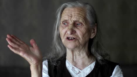 Porträt-von-alte-Frau-mit-grauen-Haaren,-die-Geschichte-zu-erzählen-und-Händen-gestikulierend.