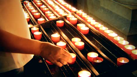 Woman-puts-a-candle-on-altar-in-church.