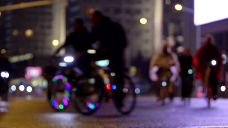 Viele-Radfahrer-fahren-während-der-Nacht-Radfahren-Fahrrad,-Fahrrad-Parade-in-Unschärfe-durch-die-beleuchtete-Nacht-Stadtstraße.-Menschenmenge-am-Fahrrad.-Radverkehr.-Konzept-Sport-gesunde-Lebensweise.-Hell-leuchtende-Lichter.-Niedrigen-Winkel-Ansicht