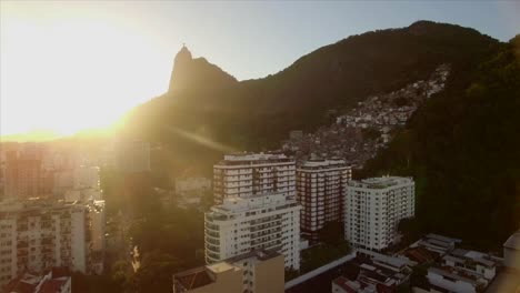 Rio-de-Janeiro-aéreo:-movimiento-hacia-Cristo-la-estatua-del-Redentor-sobre-edificios-con-favela-de-montaña-en-primer-plano